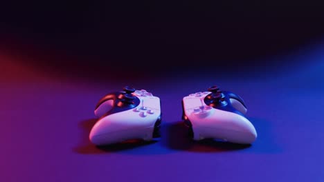 Video of close up of video game pad controllers with copy space on neon background