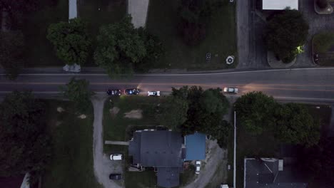 high-quality overhead drone footage capturing a dramatic scene where a car is pulled over by two police cars on a roadway