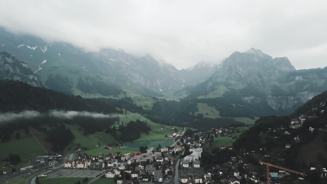 Drohnen-Luftaufnahme, die an einem bewölkten Tag über die Ortschaft Endelberg in der Schweiz in den Bergen fliegt.