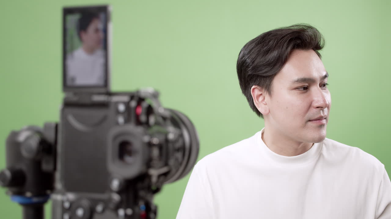 A young man adjusting his hair during a vibrant studio shoot showcasing self-expression and creativity.