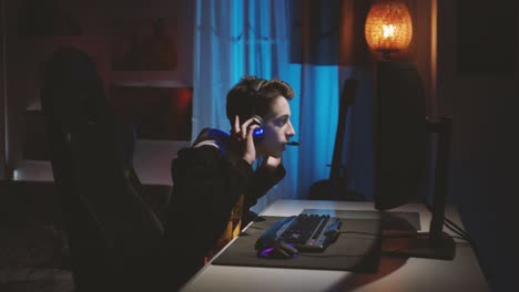헤드폰을 끼고 온라인 컴퓨터 게임을 하며 선수들과 소통하는 10대 소년