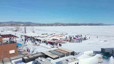 drone reveiling pan right, people preparing for canoe race