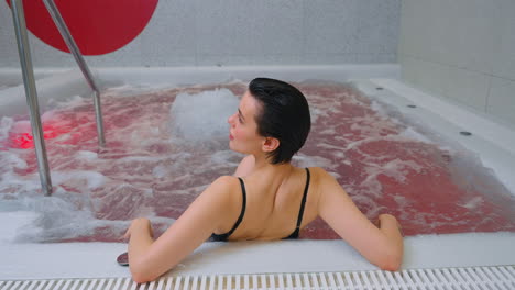 mujer relajándose en una bañera de agua caliente