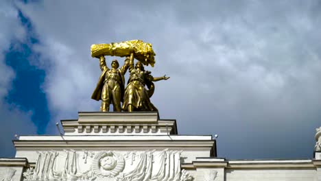 golden statue of workers on a soviet building