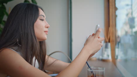 mujer usando el teléfono en un café