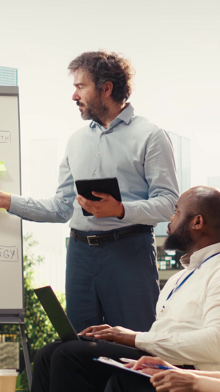 Vertical Video Diverse business team leading whiteboard presentation and explaining ideas