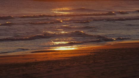 Olas-Del-Océano-En-La-Playa-De-Arena,-Amanecer-Reflejado-En-El-Agua,-Cámara-Lenta,-Costa-Mediterránea,-España