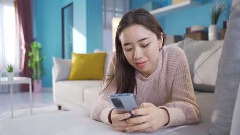 Junge-Asiatische-Frau-Schaut-Auf-Das-Telefon-Und-Benutzt-Es.