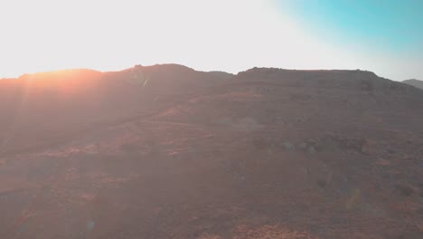 Drone-flying-towards-small-house-on-mountain