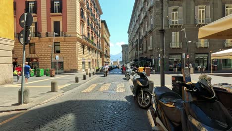 mopeds and pedestrians in a busy naples intersection