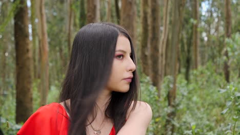 pretty young latina, brunette woman taking of her medical face mask to enjoy nature in a relaxing forest serious face portrait with long brown hair