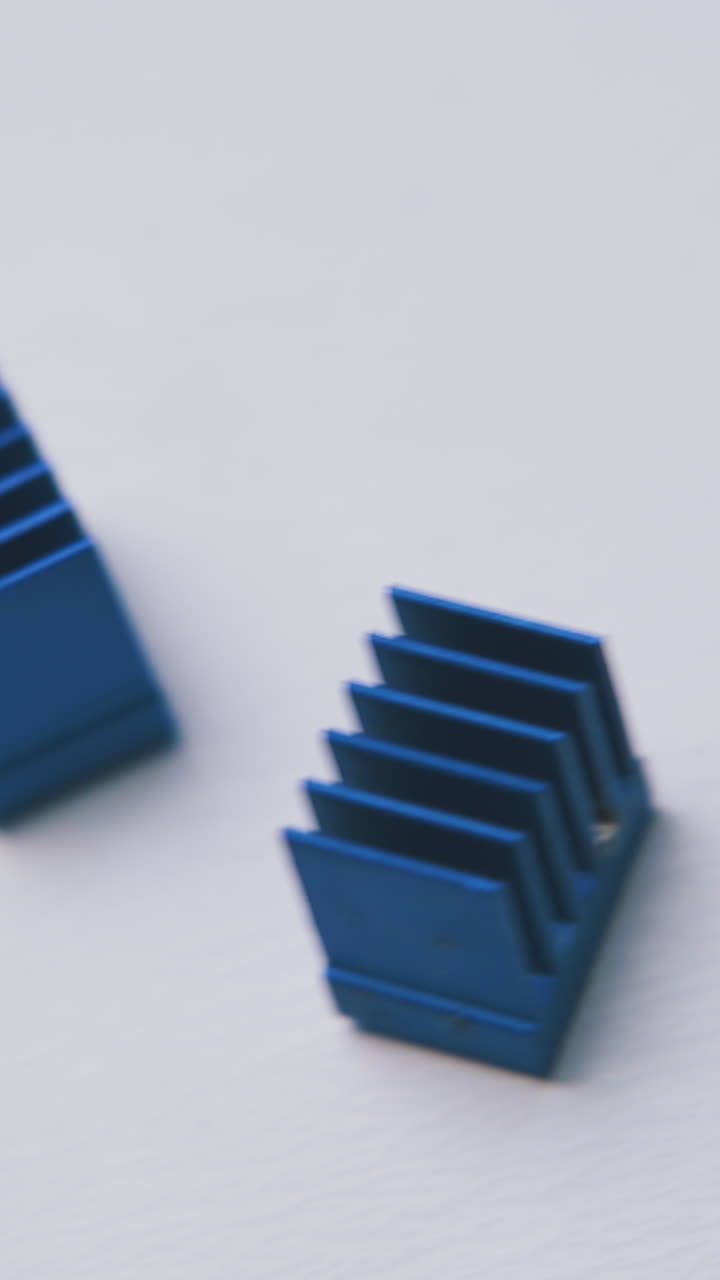 Movimiento sobre pequeños disipadores de calor azules para chips sobre fondo blanco limpio, vista de primer plano extremo.