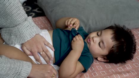 the tender moment of an 18-month-old baby boy's nappy change, captured in slow motion, highlights the concept of gentle and nurturing baby care