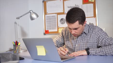 hombre trabajando en una computadora portátil en una oficina