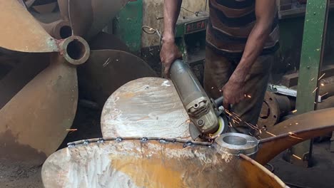 Close-up-shot-of-worker-polishes-a-propeller-in-a-propeller-manufacturing-workshop-in-Dhaka,-Bangladesh