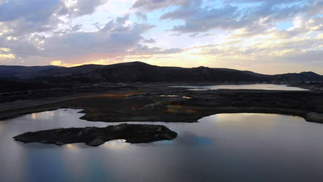 Aerial-drone-fly-in-over-dried-up-Irvine-Lake-in-Southern-California-at-beautiful-sunset--lake-is-almost-empty-due-to-drought-in-2018