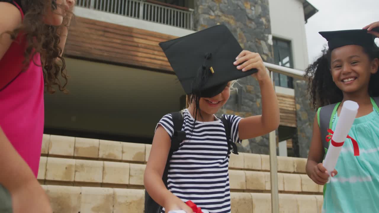 video de chicas felices y diversas lanzando sombreros después de la graduación