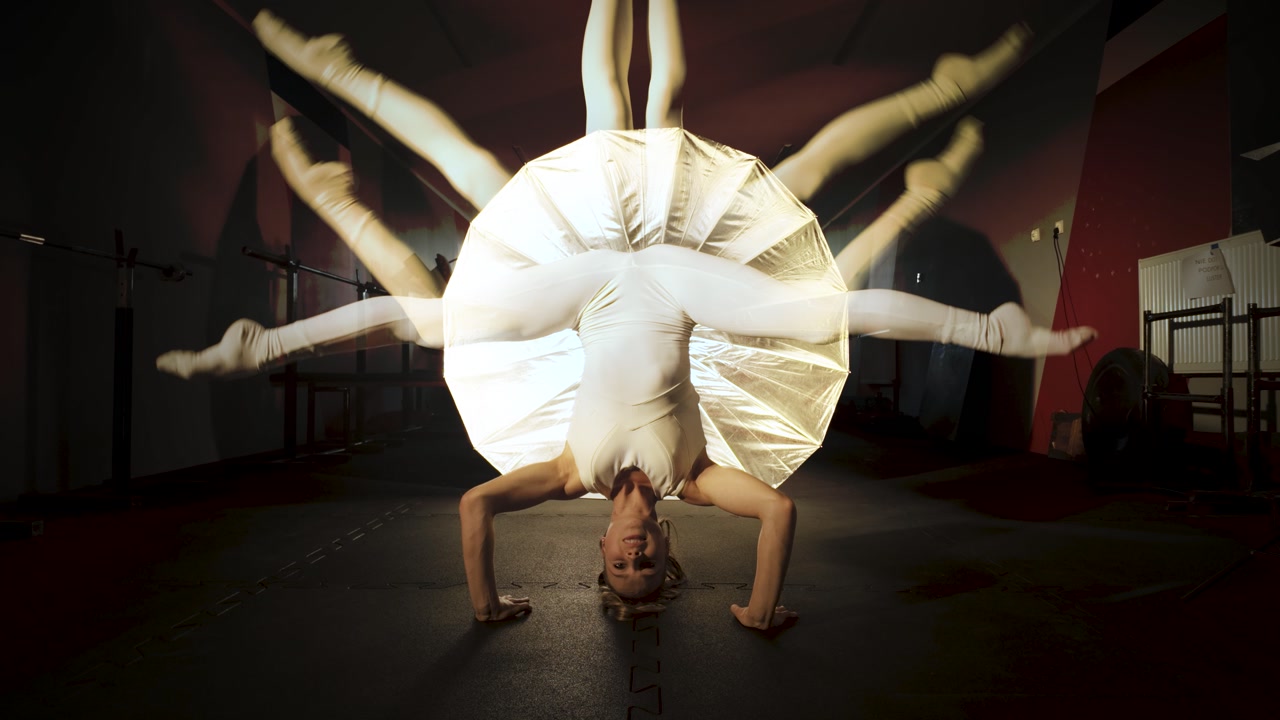 Female acrobat moving her legs, creating trippy trails of motion