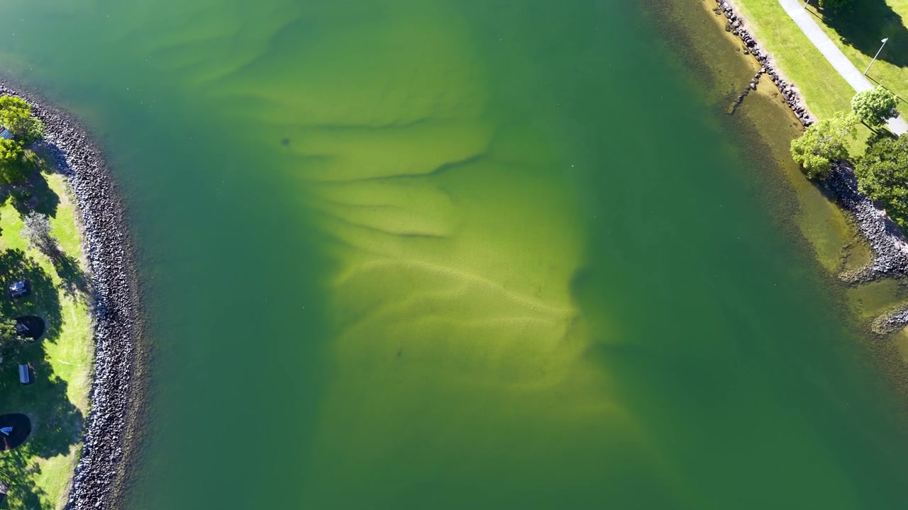 Drohnenaufnahme aus der Vogelperspektive von grünem Flusswasser und Sandbänken in Surfers Paradise, Australien
