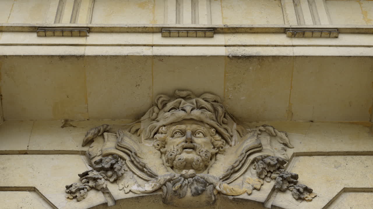 Ornate Stone Carving of a Man's Head Adorning a Building Facade
