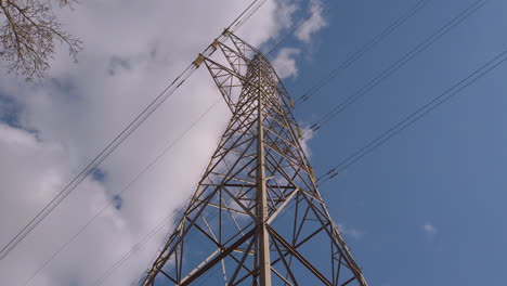 pilón de electricidad en medio de un campo de agricultores con cables que se extienden por el cielo azul y el campo