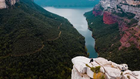 a person dressed in all black is sitting on a cliff in tavertet