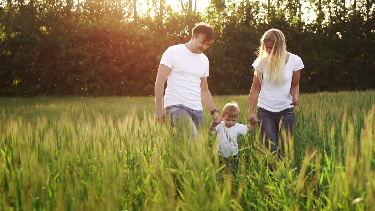 아버지와 아들은  ⁇  티셔츠와 청바지를 입고  ⁇ 니와 함께  ⁇ 에서 걸어가며 손에 흔들고 재미있습니다.