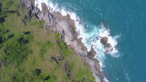 aerial view drone camera top down of seashore rocks in a blue ocean beautiful sea surface amazing sea waves crashing on rocks seascape aerial view drone 4k high quality of ocean with stone rock cliff