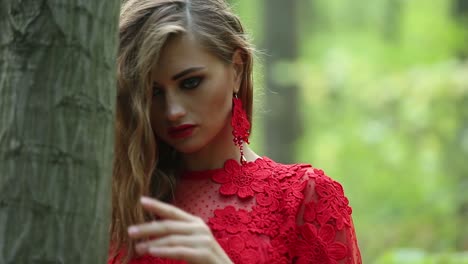 pretty woman explores beautiful forest. pretty woman in a long red dress explores beautiful forest
