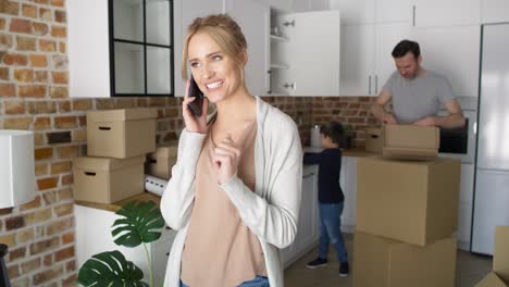 Happy-woman-calling-and-holding-keys-to-a-new-house