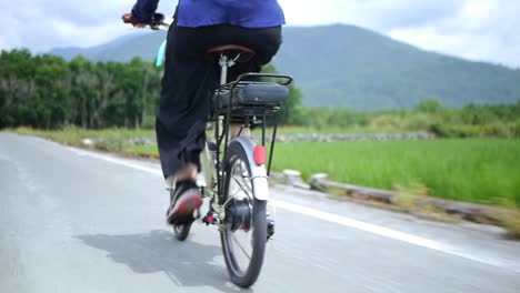 亞洲女性在鄉村觀光旅行時騎單車,從騎手的後面拍攝中等拍攝