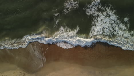 ocean waves crashing on sandy shore