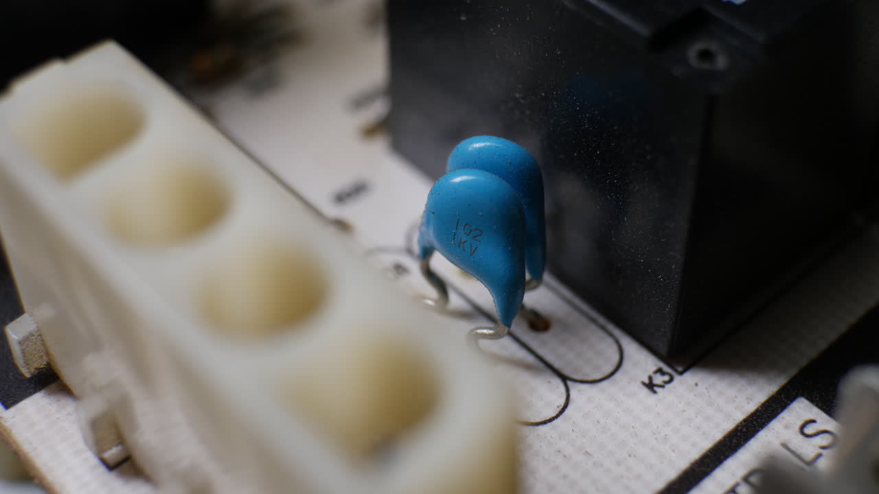 A capacitor and other electronic components on an old retro circuit board controller