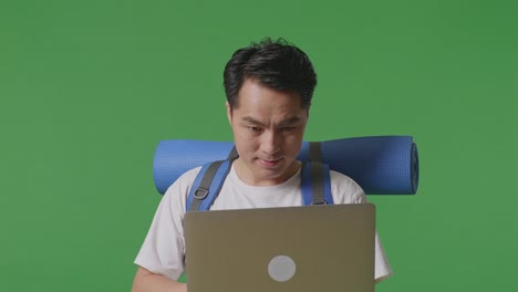 man working on laptop with backpack
