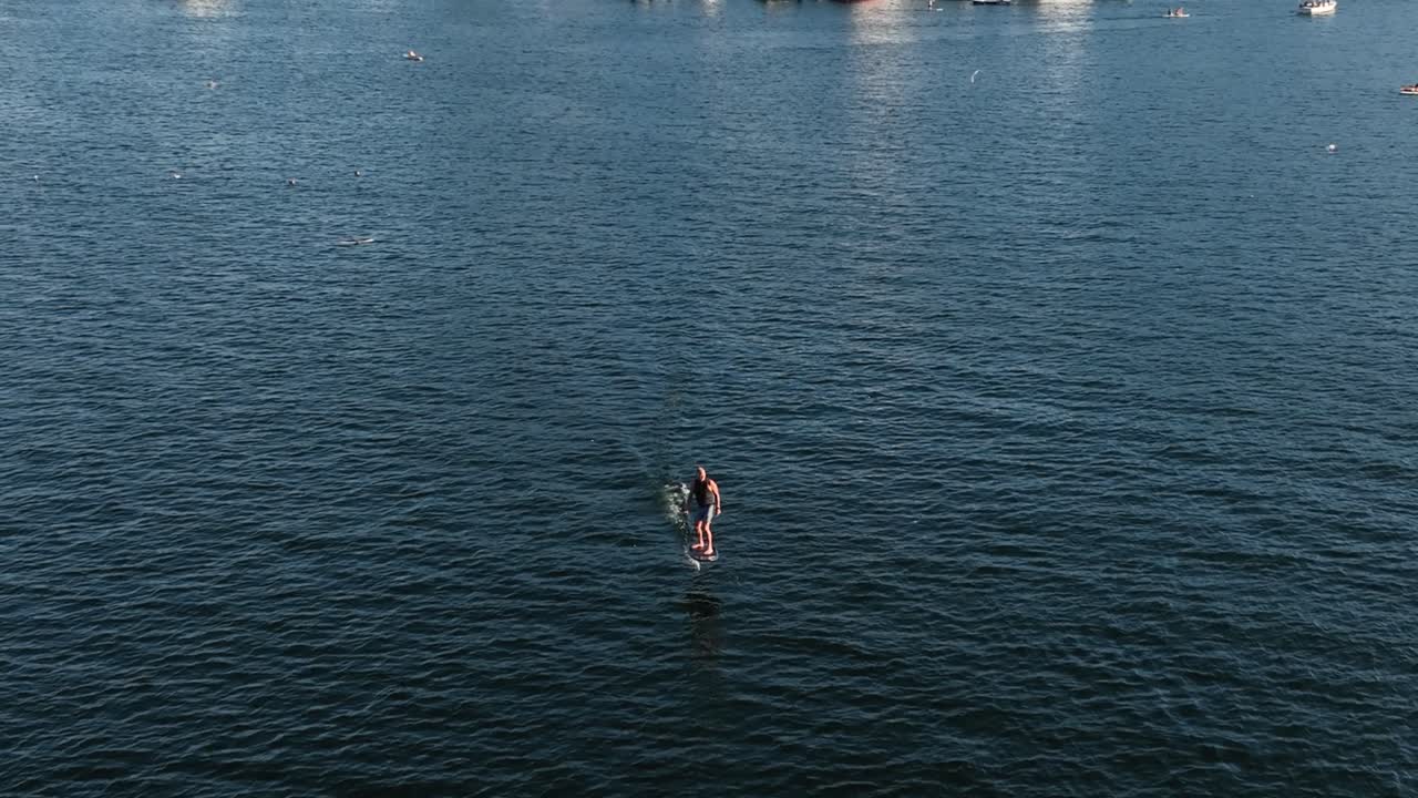 vista aérea de una tabla de surf eléctrica navegando a través de la unión del lago
