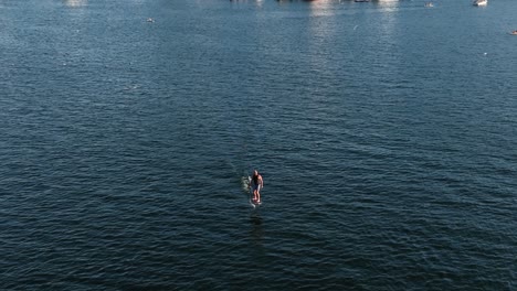 aerial view of an electric surfboard rider cruising through lake union