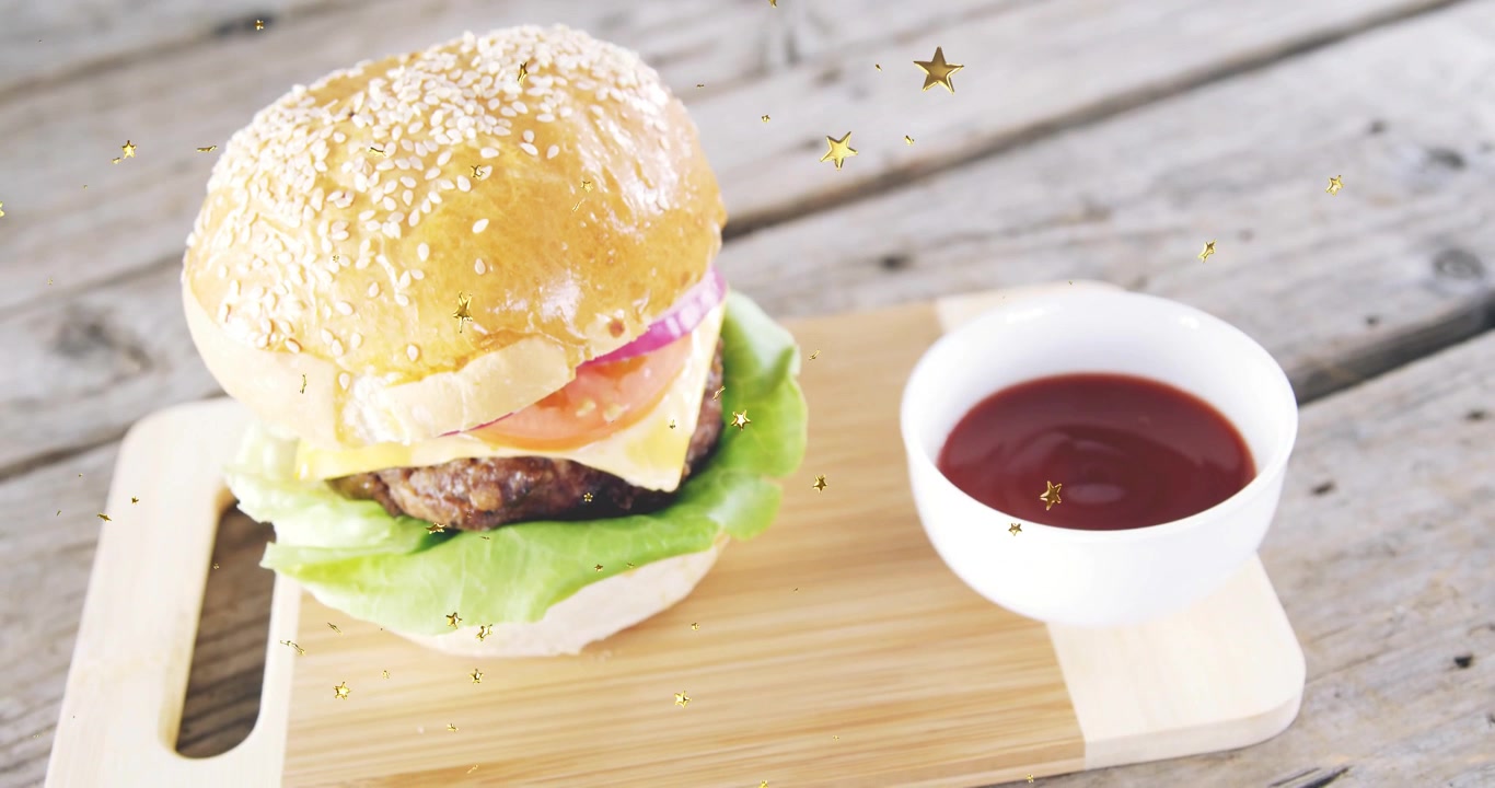 Cascata di stelle dorate che inizia, hamburger su un tagliere, la visuale si sposta e le stelle fluttuano mostrando il prodotto.