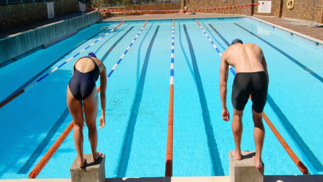 4k 수영장에서 다이빙을 준비하는 남성과 여성 수영 선수