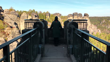mujer en la cubierta de observación en el puente bastei, saxonia, alemania