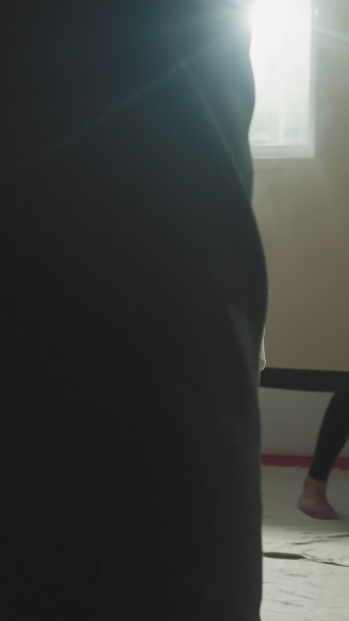 niño patea una bolsa de boxeo con la rodilla en un club deportivo. niño pequeño estudia kickboxing con deportistas adultos en el gimnasio de lucha en cámara lenta. atleta junior