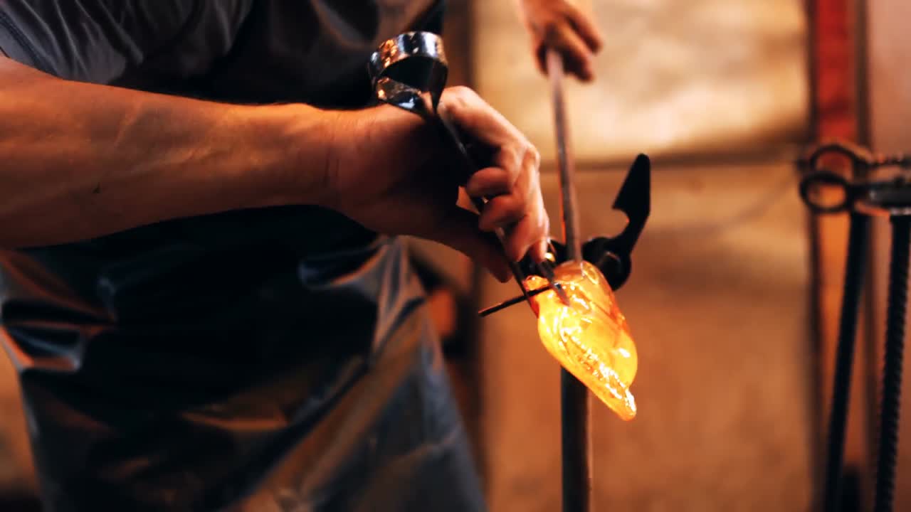 sección media de un soplador de vidrio que da forma a un vidrio fundido