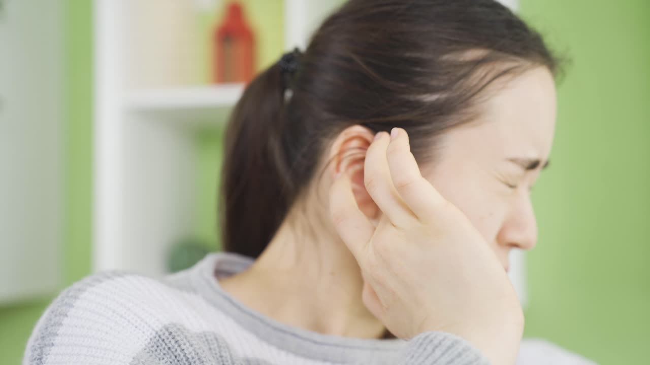mujer joven asiática con inflamación en el oído sintiendo dolor y dolor.