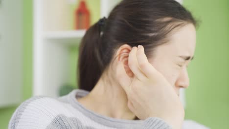 귀에 염증이 있는 젊은 아시아 여성이 통증과 통증을 느끼고 있습니다.