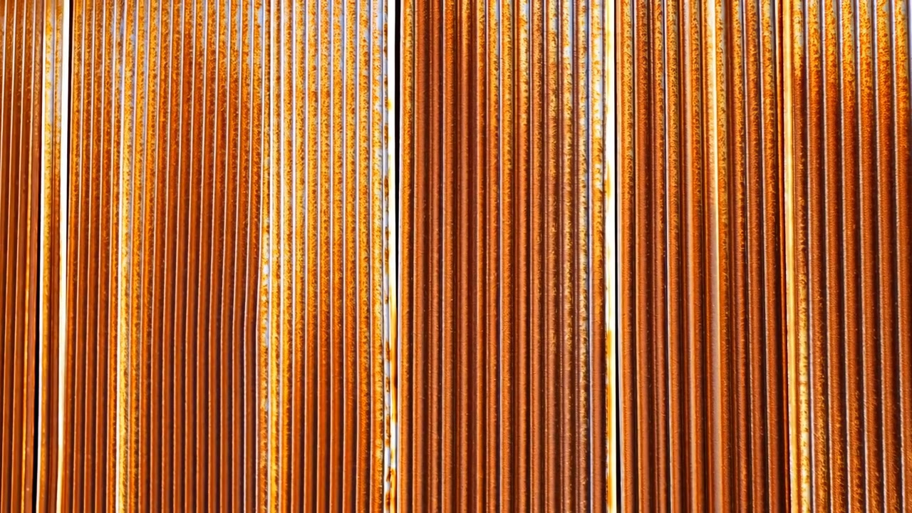 A close-up side view of vertical wooden slats in an indoor setting, showcasing neutral tones and warm lighting. This architectural element is ideal for interior design projects, commercial.