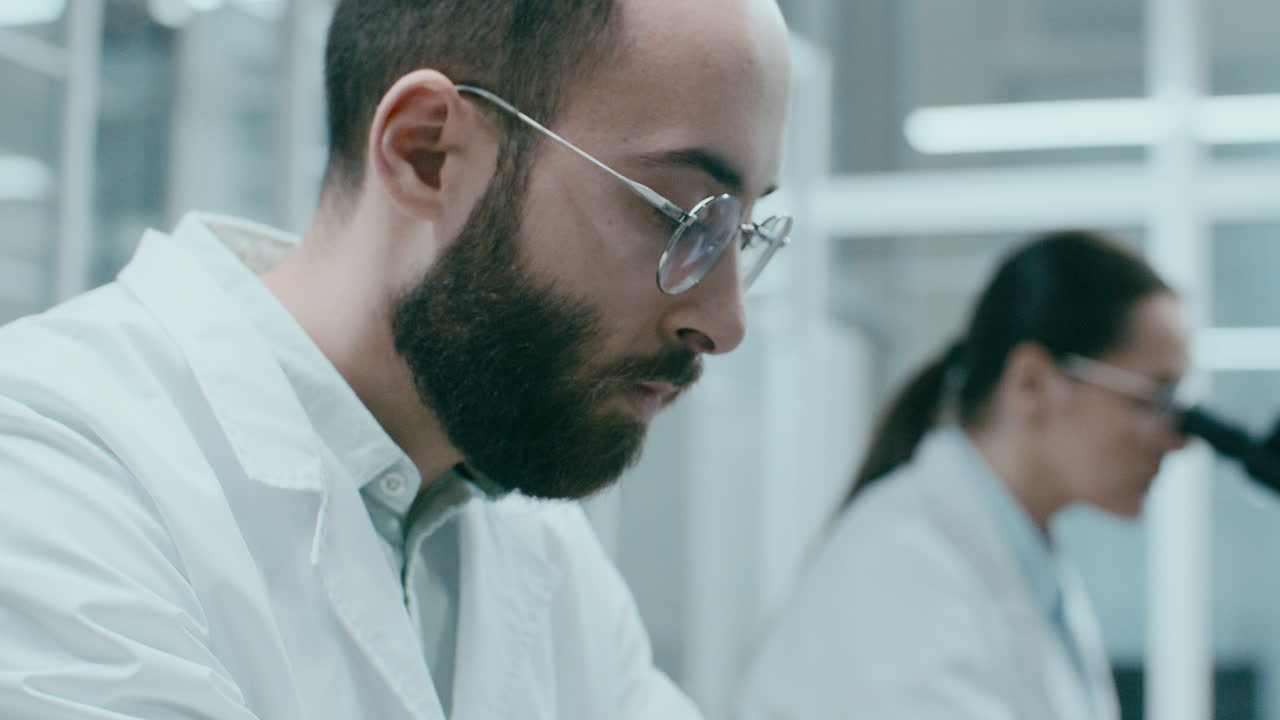 Primo piano di scienziato di laboratorio che digita informazioni di ricerca su laptop