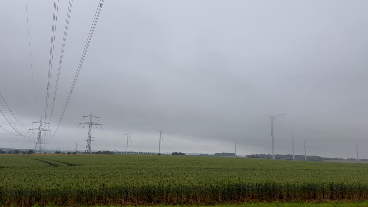 Power Lines and Wind Turbines in a Cloudy Rural Landscape