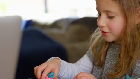 girl playing with clay in living room 4k
