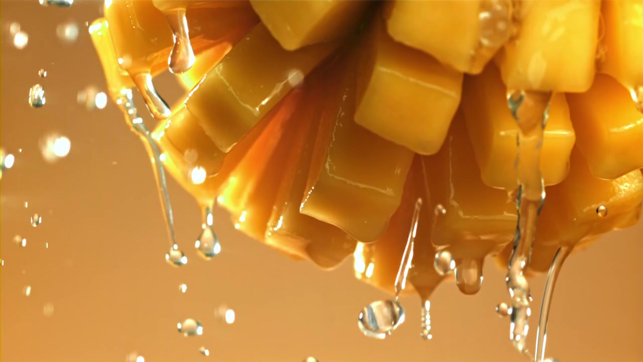 Primo piano di schizzi d'acqua su cubetti di mango fresco.