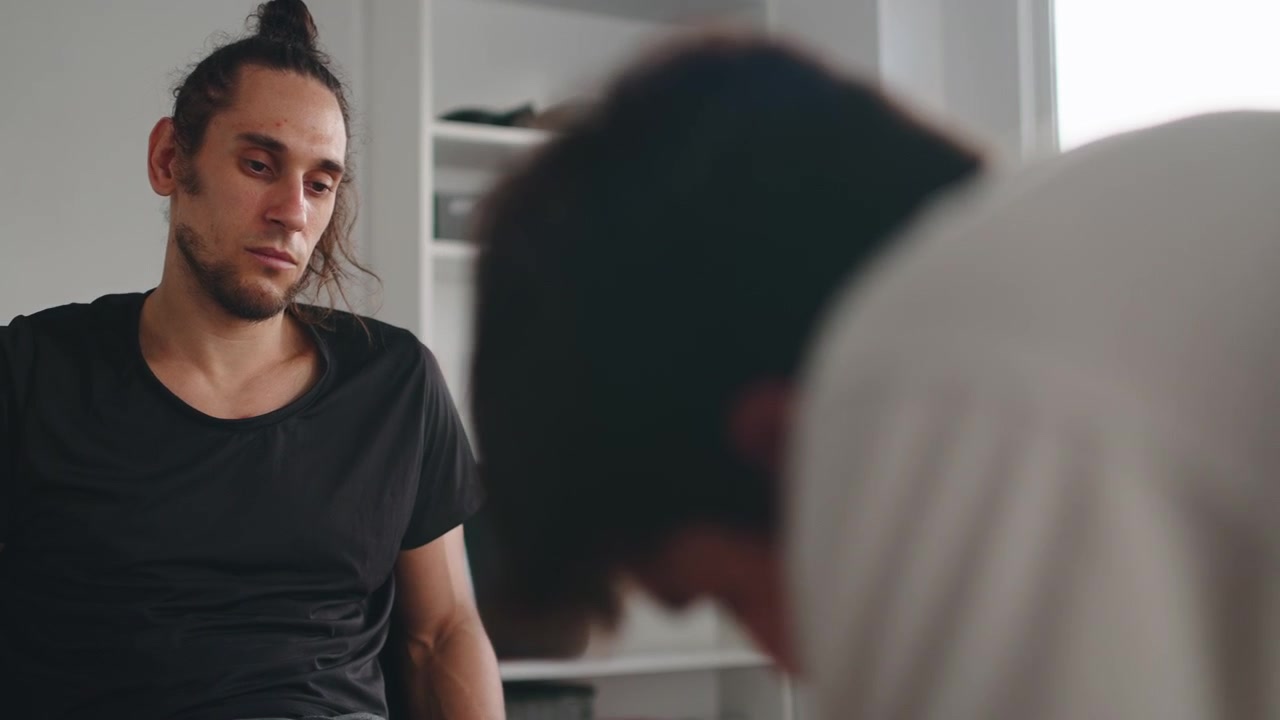 Young Man Sitting and Listening During a Serious Conversation