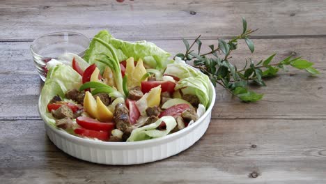 Sprinkling-pink-pepper-corns-onto-a-bowl-of-fresh-salad